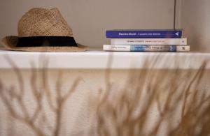 a hat sitting on top of a shelf with books at Porto Sole Rooms in Portoferraio