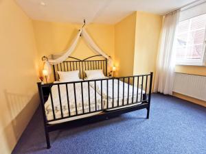 a bedroom with a large bed with a canopy at Alte Rathausschänke - Hotel Garni in Hannoversch Münden