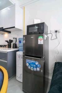 een keuken met een magnetron en een koelkast bij NOVAH Apartments NAIROBI KENYA in Nairobi
