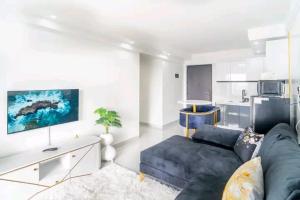 een woonkamer met een blauwe bank en een keuken bij NOVAH Apartments NAIROBI KENYA in Nairobi