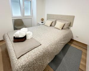 um quarto com uma cama grande com toalhas em R3 - Casinha PP GH em Coimbra
