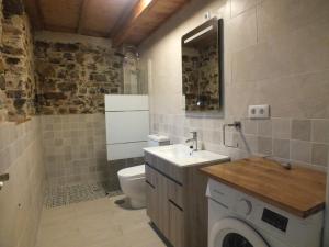 a bathroom with a toilet and a sink and a washing machine at Apartamentos Rurales Casa Llucas in San Julián +11 photos