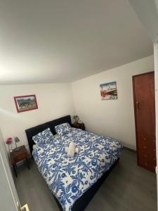 a bedroom with a bed with a blue and white comforter at studio de la gare in Vesoul