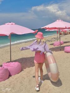 Una donna è in piedi sulla spiaggia con una boa di salvataggio di La Mer Boutique House a Cù Lao Thu