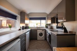 a kitchen with a washer and dryer in it at Westbourne House By Horizon Stays in South Bank