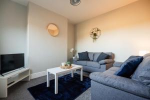 a living room with a couch and a tv and a table at Westbourne House By Horizon Stays in South Bank