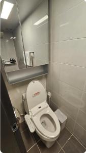 a small bathroom with a toilet and a mirror at Seomyeon MZ Stay in Busan