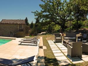 a backyard with a pool and chairs and a house at La Ferme les Eybrachas in Réauville