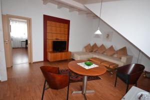a living room with a table and a couch at Weinhaus Steppe Hotel 3***Superior und Weinstube in Waldbronn