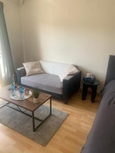 a living room with a couch and a coffee table at Chambre d'hôte chez Kahi in Brunoy