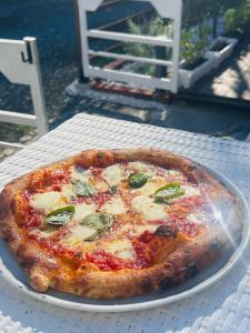 a pizza sitting on a white plate on a table at The Surf Lodge White Beach in Shimoda
