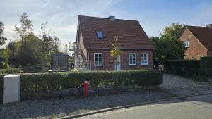 a red fire hydrant in front of a house at FeWo Gisela in Fehmarn