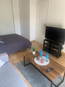 a living room with a coffee table and a piano at Chambre d'hôte chez Kahi in Brunoy