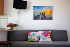a living room with a couch with a painting on the wall at Stefanie Studios in Egina
