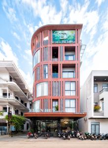 Un edificio alto y rojo con un cartel. en Eden Hue Hotel, en Hue