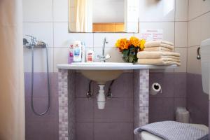 a bathroom sink with a vase of flowers on it at Stefanie Studios in Egina