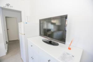 een flatscreen-tv op de top van een witte dressoir bij House Beach Park in La Herradura