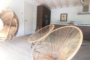 2 rieten stoelen in een kamer met een keuken bij Nia Domo, Ringdijk Noord 22a in Cadzand