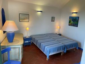 a bedroom with a bed and a table with a lamp at Maison ancienne rénovée avec vue sur mer et Cap Corse in Centuri