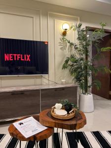 a living room with a table and a tv at Casa Bianca- Flat in Islamabad in Islamabad +7 photos