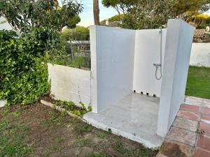 a white fence with a shower in a yard at Pinos Verdes in Chiclana de la Frontera +11 photos