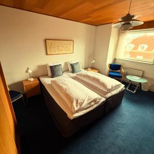 a bedroom with a bed and a table and a window at BUDGET HOTEL Viborg in Viborg +2 photos
