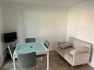 un soggiorno con un divano, un tavolo e delle sedie di Appart Gwen a Gruissan