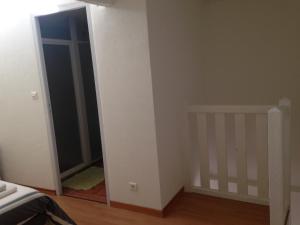 a room with a bedroom with a door and a crib at Maison 2 couchages in Roquecor