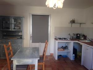 a kitchen with a table and a table and chairs at Maison 2 couchages in Roquecor