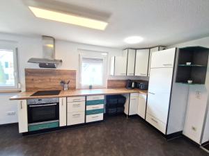 a kitchen with white cabinets and a white refrigerator at Traumwohnung mit Sonnen-Balkon - nur 5 min vom EP in Rheinhausen