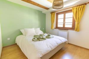 a bedroom with a bed with white sheets and a window at Ide'Alsace in Eguisheim