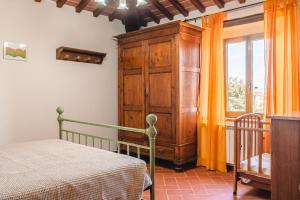 a bedroom with a bed and a wooden cabinet at Villa Lo Stemma in Monte San Savino +55 photos