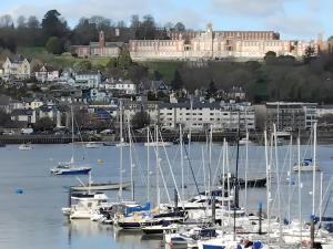 a group of boats docked in a harbor with a castle at The Garden Room at Dartmouth in Dartmouth
