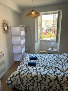 a bedroom with a bed with blue pillows on it at Gîte Cosy - 35 m2 - T2 Hyper Centre - Tout équipé in Langeac