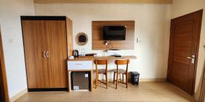 a kitchen with two chairs and a counter with a television at Villa Kopiori in Yogyakarta