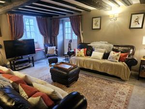 a living room with a couch and a tv at Holly Cottage in Hutton le Hole