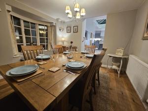 a dining room with a wooden table and chairs at Holly Cottage in Hutton le Hole