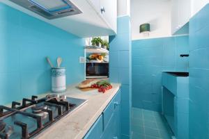 a blue kitchen with a stove and blue tiles at Estate4home - Suite Bonview in Massa Lubrense