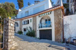 a white building with a gate and a garage at Estate4home - Suite Bonview in Massa Lubrense