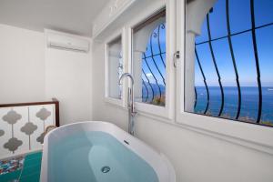 a bathroom with a bath tub and a window at Estate4home - Suite Bonview in Massa Lubrense