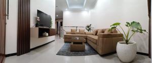 a living room with a couch and a vase with a plant at CABI'N Homestay in Jarakan