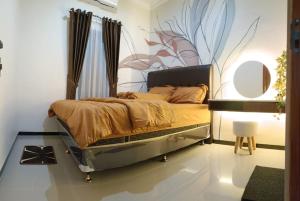 a bedroom with a bed with a flower mural on the wall at CABI'N Homestay in Jarakan