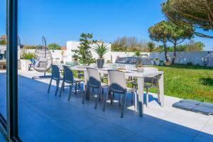 a table and chairs sitting on a patio at magnifique villa avec piscine - 8 personnes - paracou in La Chaume