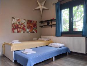 a bedroom with two beds and a window at Mona Lisa Guest House in Volos