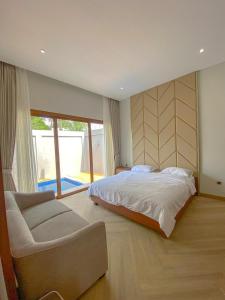 a bedroom with a bed and a couch and a window at Lavanda Villas Puncak in Cisarua +36 photos