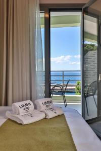 a bedroom with a bed with a view of the ocean at LIMNI Boutique Experience Evia in Limne