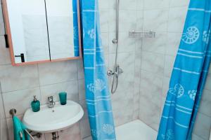 uma casa de banho com um lavatório e um chuveiro em Apartments puntaplanka direkt am meer em Razanj
