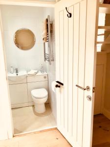 a white bathroom with a toilet and a sink at Peaceful Scandi Garden room in Falmouth