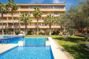 an apartment with a swimming pool in front of a building at Alborada Golf 13C in L’Alfàs del Pi
