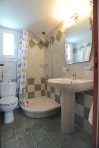 a bathroom with a sink and a toilet and a mirror at Veranta Me Thea in Agios Ioannis
